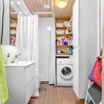 Bathroom with washing machine, shower, and mirror cabinet.