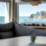 From the living room, you can see the sea and a wooded coastline.