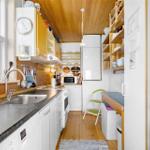 Kitchen with worktop, sink and appliances. Wooden ceiling and floor.