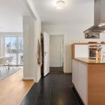 Kitchen with wooden surfaces and dining area with table and chairs.