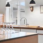 Kitchen with wooden countertop, window, faucet, and wine bottle.