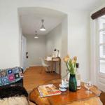 Living room with sofa, table, and view into hallway with desk.