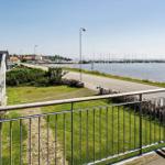 View from balcony over water, marina, road, and green areas.