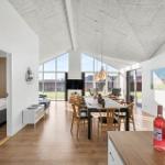 Large dining room with wooden floor and big window. Bedroom is visible.