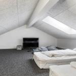 Room with sloped ceiling, mattresses, and TV