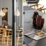 Dining table with chairs, mugs, and newspaper. Hanging lamps and view into bedroom.