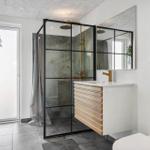 Bathroom with shower stall, sink, and toilet. Wooden and metal accents.