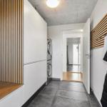 Hallway with washing machine, wooden wall, and coat rack
