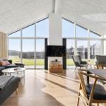 Large living room with glass front, sofa, dining table, and TV.