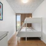 Bedroom with bunk bed and window to outdoor terrace.