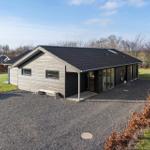 Modern villa with wooden facade and large garden. Garage and terrace are available.