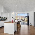 Kitchen with island, hardwood floor, and large window to garden.