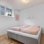 Schlafzimmer mit Bett, Fenster und Deckenleuchte.
