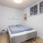 Schlafzimmer mit Bett, Fenster und Wandbild.