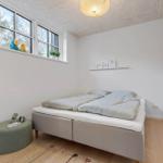 Schlafzimmer mit Doppelbett, Fenster und Holzboden.