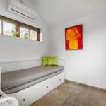 Schlafzimmer mit Fenster, Bett und Wandbild.