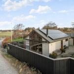 Moderne Ferienhaus mit Terrasse und Garten. Blick auf Felder und Bäume.
