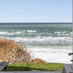 View of the sea from a window with beach and birds.
