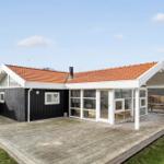 Modern villa with wooden terrace and large glass area.