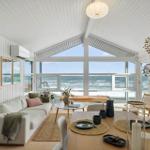 Living and dining area with ocean view through large windows.