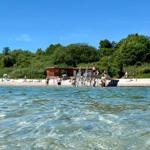 Beach with diving board and people under blue sky