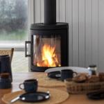 Dining table with fireplace and view of outdoor area.