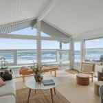 Living room with large windows overlooking the sea and beach.