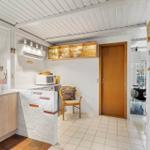 Kitchen with countertop, sink, microwave, and chair.