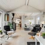 Living area with dining space, black leather chairs, and light wood floor.