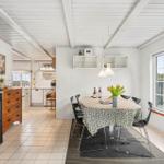 Dining area with table, chairs, and view to balcony. Kitchen and fireplace in background.