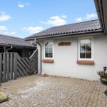 House with terrace, shed, and rustic grill. Snow covers the ground.