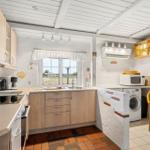 Kitchen with sink, window, microwave, and washing machine.