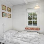 Bedroom with white walls, window, and bed.