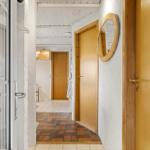 Hallway with wooden doors, round mirror, and tiled floor