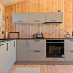 Modern kitchen with wooden walls and built-in oven.