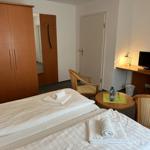 Room with double bed, desk, TV, and wardrobe.