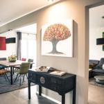 Essbereich mit Tisch und Stühlen. Wohnzimmer mit Sofa und Wandbild.