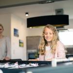 Eine Familie spielt Foosball in einer modernen Küche.