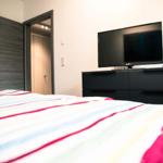 Schlafzimmer mit Bett, TV und Schrank