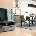 Wohn- und Essbereich mit TV, Tisch und Stühlen.