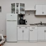 Küche mit Kühlschrank, Mikrowelle und Spüle.