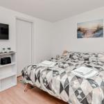 Schlafzimmer mit Bett, Fernseher und Küchenutensilien.