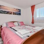 Schlafzimmer mit Bett, Nachttisch und Fenster mit Vorhängen.