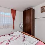 Schlafzimmer mit Bett, Garderobe, Fenster und Klimagerät.