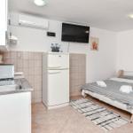 Kleine Wohnung mit Schlafzimmer, Küchenzeile und Kühlschrank.