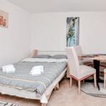 Schlafzimmer mit Bett, Esstisch und Wandbild.