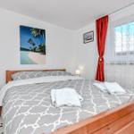 Schlafzimmer mit Bett, Nachttisch und Fenster mit roten Vorhängen.