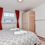 Schlafzimmer mit Bett, Kleiderständer und Kleiderschrank