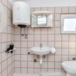 Badezimmer mit Waschbecken, Toilette und Duschbereich.