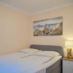 Schlafzimmer mit Bett, Nachttisch und Wandbild